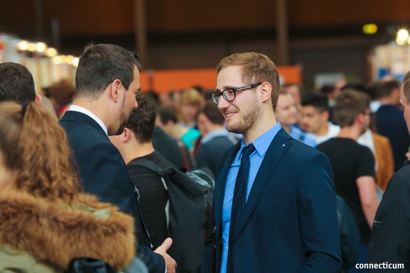 Besucher im Anzug in der Messehalle